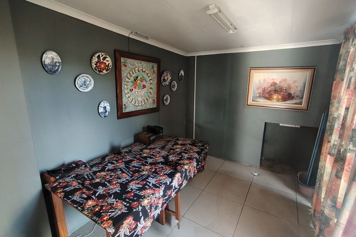 A living area featuring tiled flooring and dark grey walls, offering a blank canvas for potential interior updates and modernization.