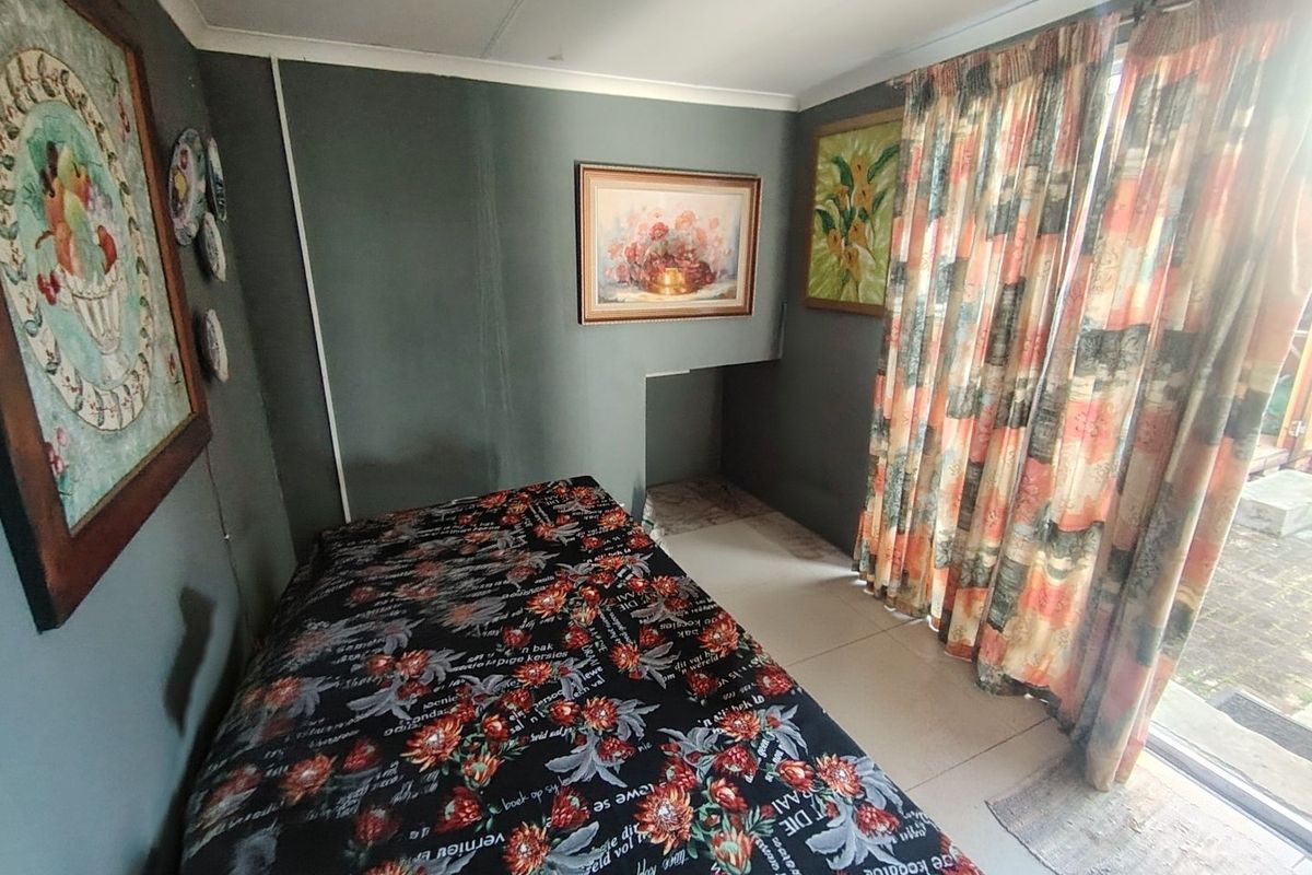 A bedroom featuring tiled flooring and a sliding glass door providing access to the exterior.