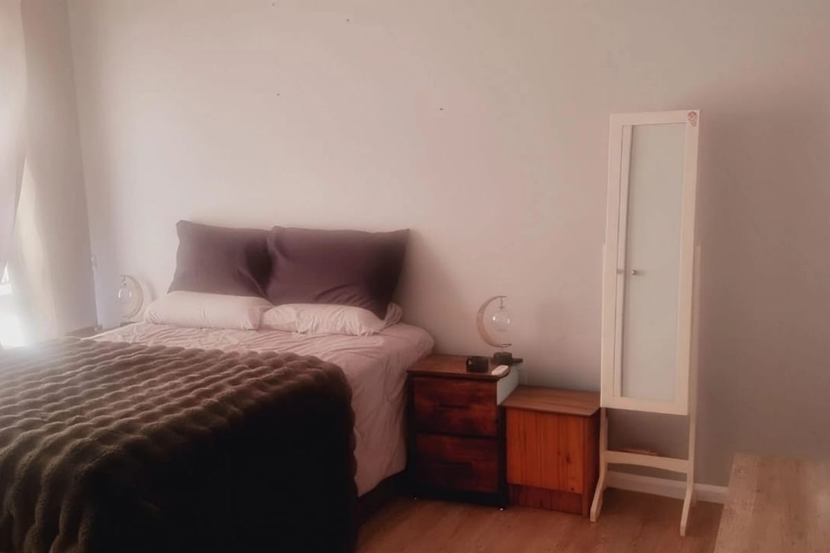 A bedroom featuring laminate flooring and neutral wall finishes, providing a functional space for rest.