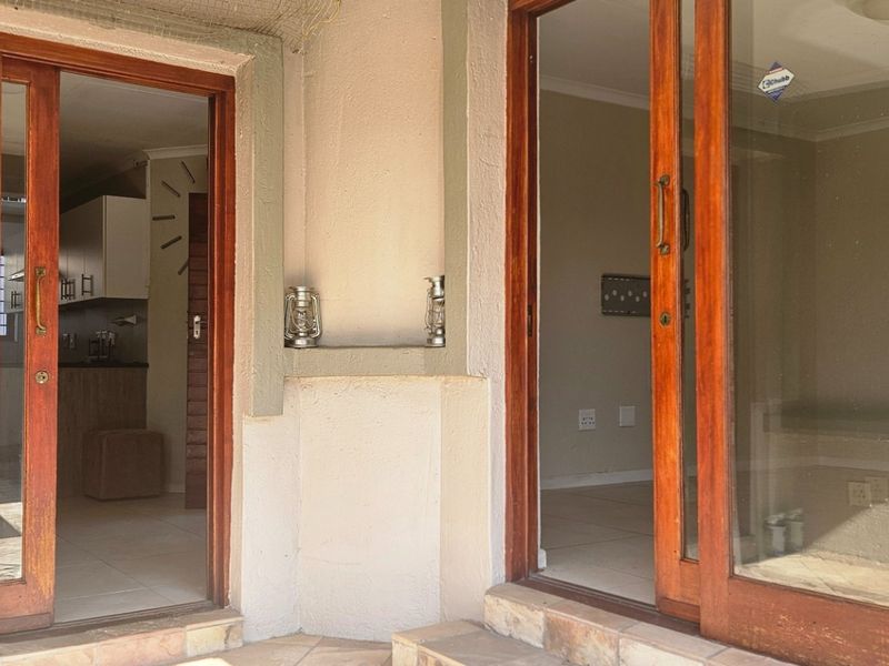 Covered patio area featuring timber sliding doors providing access to the interior living and kitchen spaces.