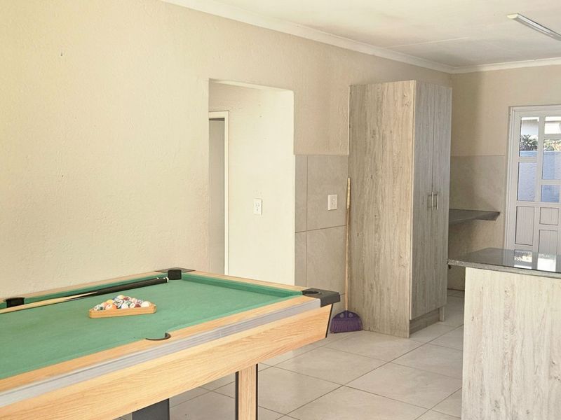 Open plan living area featuring a kitchen with granite countertops, tiled flooring, and neutral wall finishes.