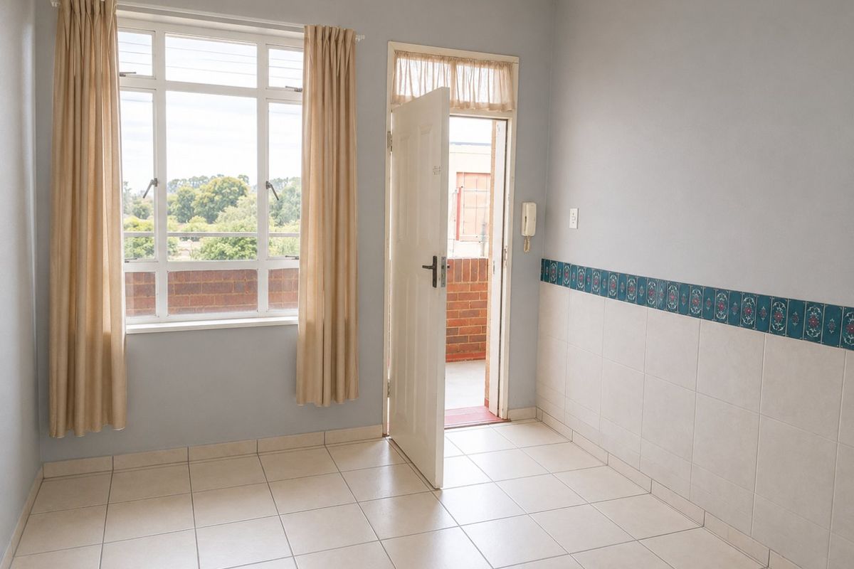 An empty living area featuring tiled floors, half-wall decorative tiling, an intercom system, and direct access to an outdoor balcony through a door.