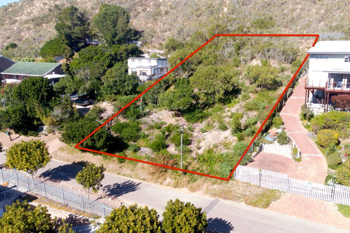 An elevated aerial view of a vacant residential plot, showing the site boundaries, surrounding vegetation, and proximity to existing neighboring properties.