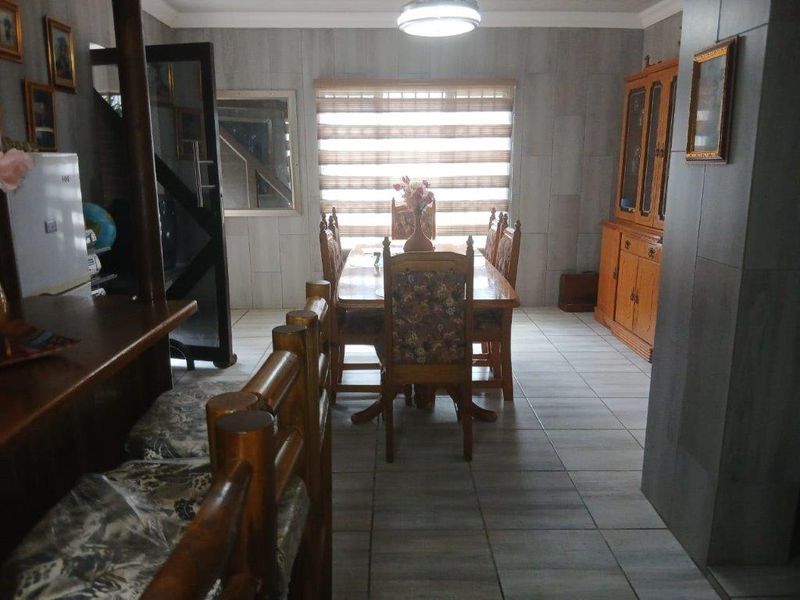 A dining room featuring tiled flooring, neutral wall finishes, and built-in cabinetry, providing a functional space for family meals.