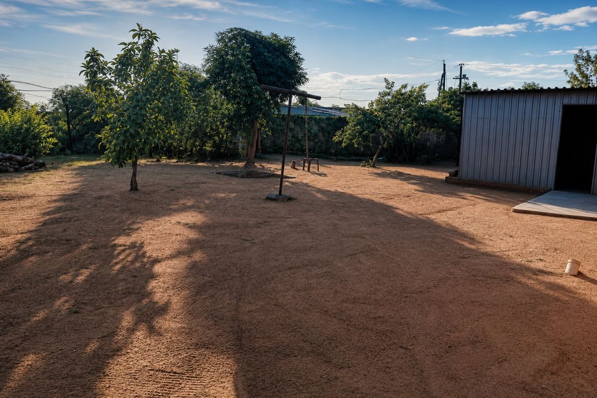 Spacious backyard area featuring a metal storage shed, mature trees, and an open dirt ground surface, offering potential for landscaping and outdoor development.