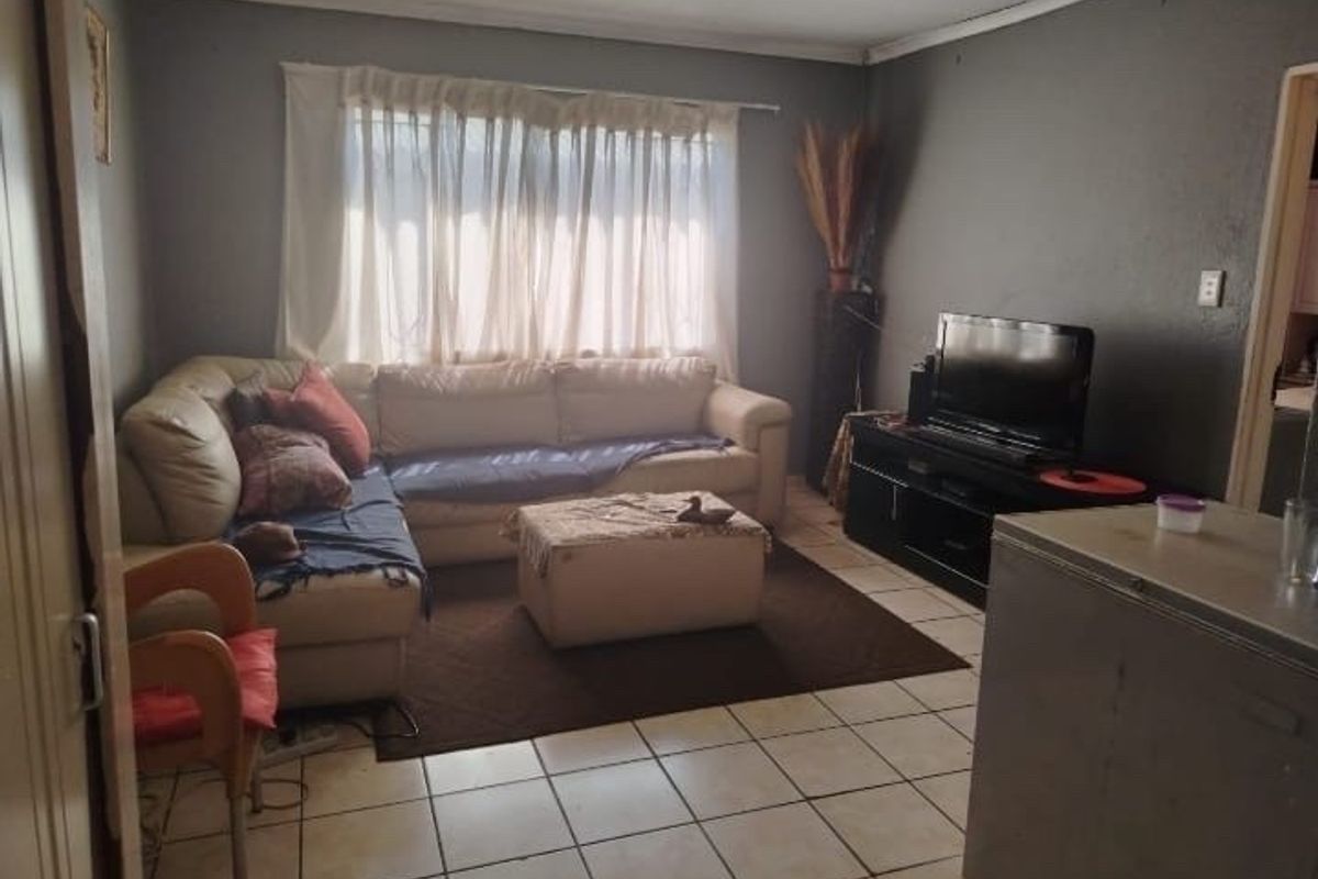 A living room featuring tiled flooring and coved ceiling details, providing a functional space for relaxation.