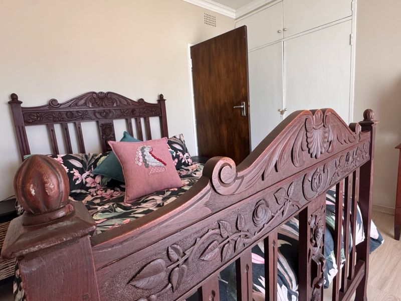 A bedroom featuring laminate flooring and built-in cupboards, providing functional storage space within the room.