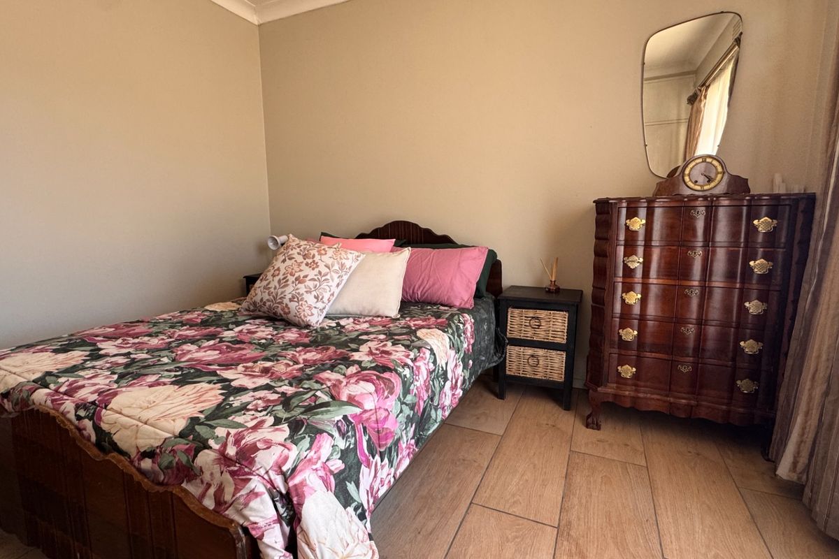 A bedroom featuring tiled flooring and neutral wall finishes, providing a functional space with standard architectural elements.