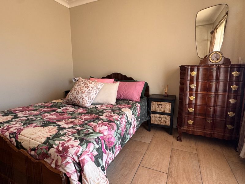 A bedroom featuring tiled flooring and neutral wall finishes, providing a functional space with standard architectural elements.