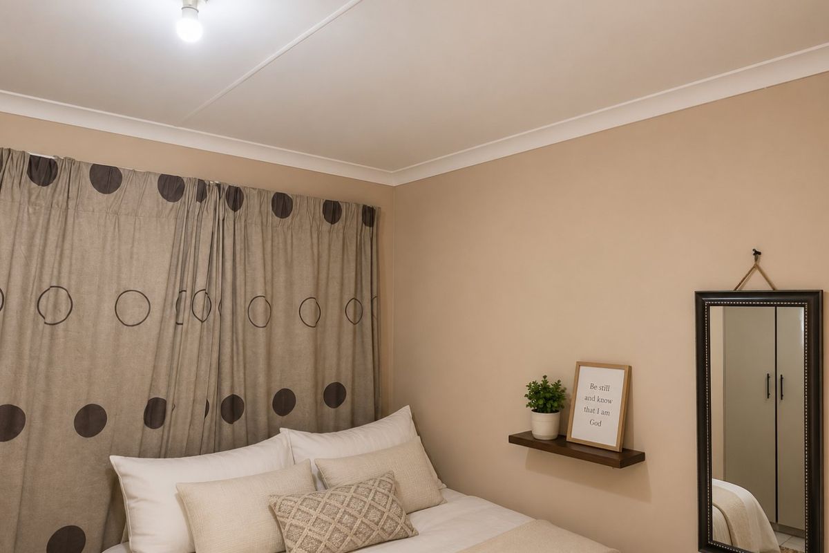 A cozy bedroom featuring neutral wall tones, a built-in wardrobe, and simple ceiling finishes.