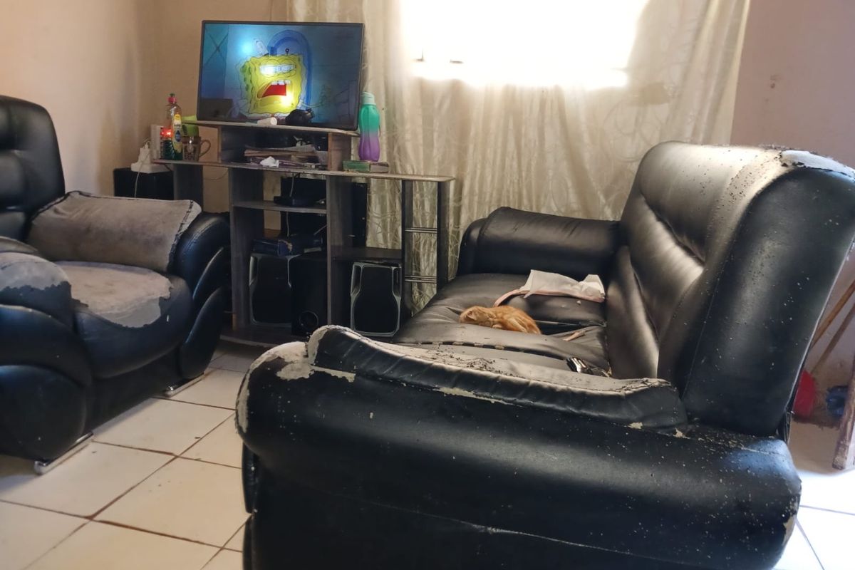 A living room area featuring tiled flooring, currently used as a casual lounge space.
