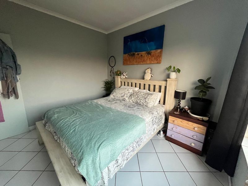 A functional bedroom featuring neutral wall tones and tiled flooring, providing a clean and simple foundation for personal styling.