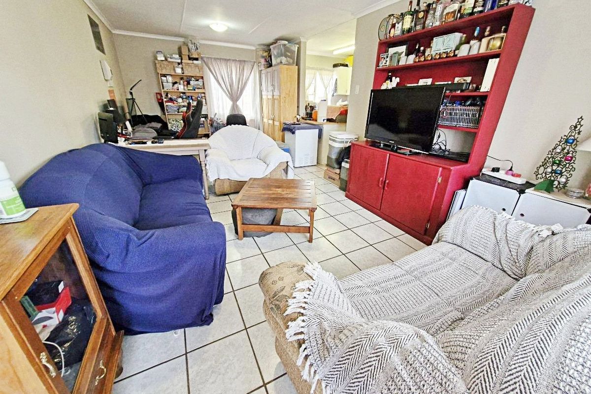 A living room area featuring ceramic floor tiles, providing a functional space with direct access to the adjacent kitchen area.