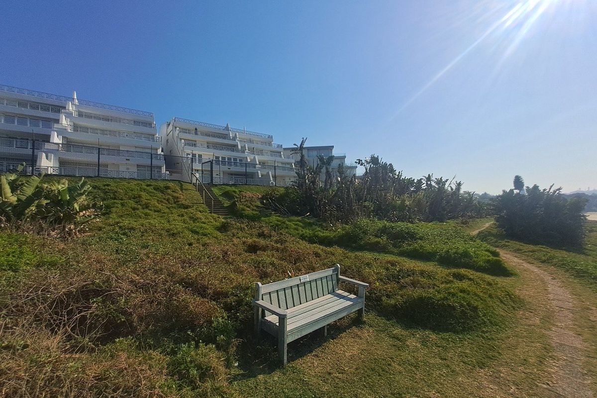 View of the apartment complex rear elevation from the adjacent landscaped grounds and walking path.