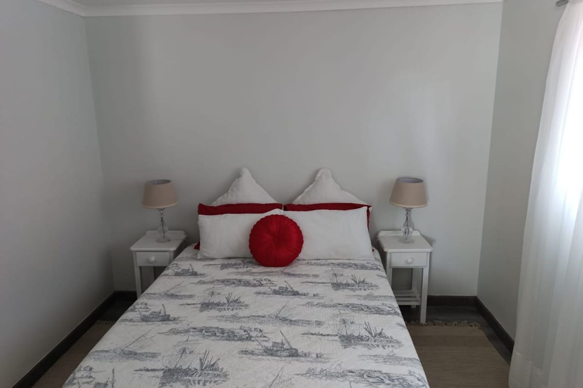 A clean and well-maintained bedroom featuring neutral wall finishes, cove cornicing, and dark skirting boards.