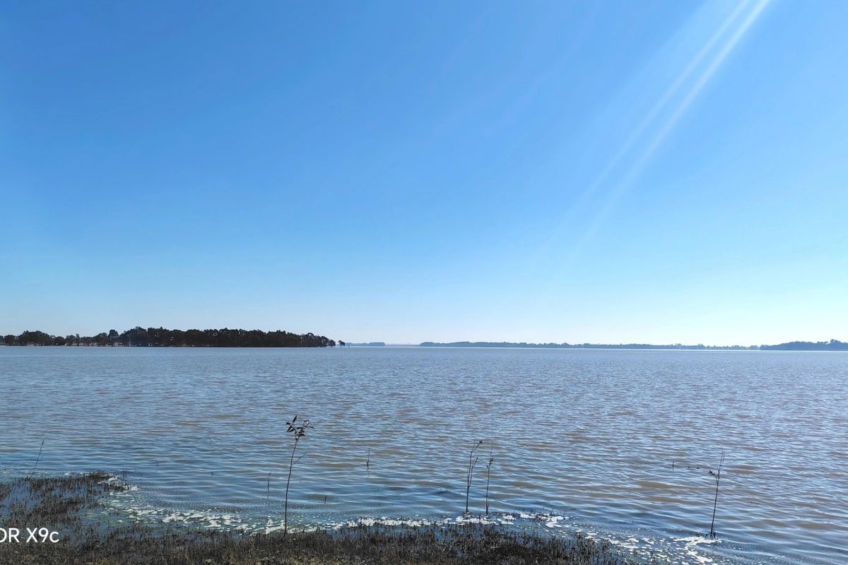 A scenic view of a large lake or dam landscape, showcasing the natural water frontage of the property.