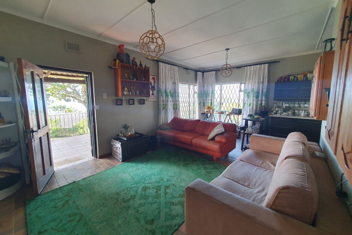 A spacious living room featuring tiled flooring, built-in cabinetry, and direct access to an outdoor patio area through a secure door.