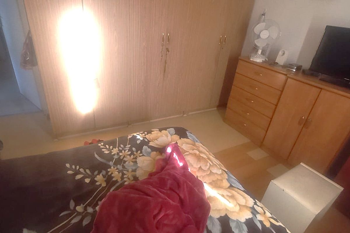 A bedroom featuring built-in wooden cupboards, providing ample storage space within the room.