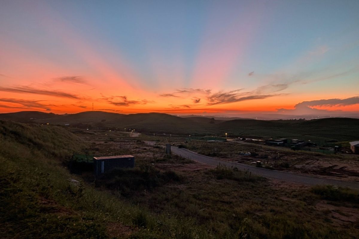 A scenic sunset view overlooking the vacant residential land, featuring rolling hills and a clear horizon.