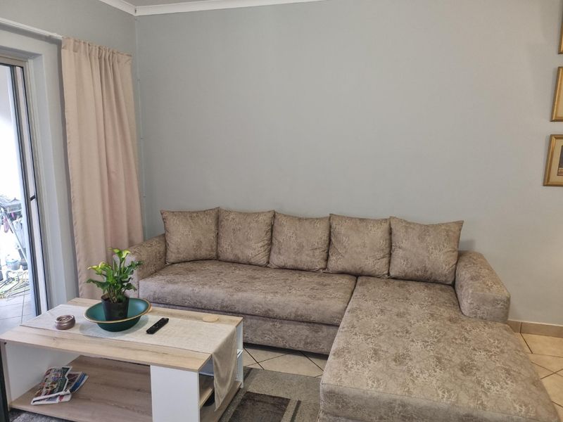 A living room area featuring tiled flooring and a sliding glass door providing access to the exterior.