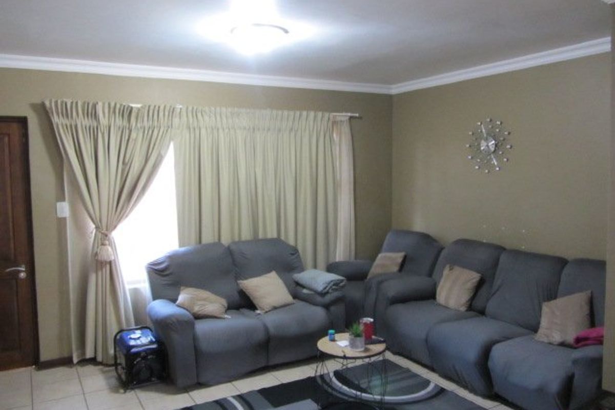 A comfortable living room featuring tiled flooring and neutral wall tones, providing a functional space for relaxation.