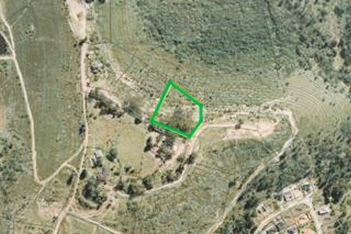 Aerial view of a vacant residential land plot with green boundary highlighting the property perimeter.