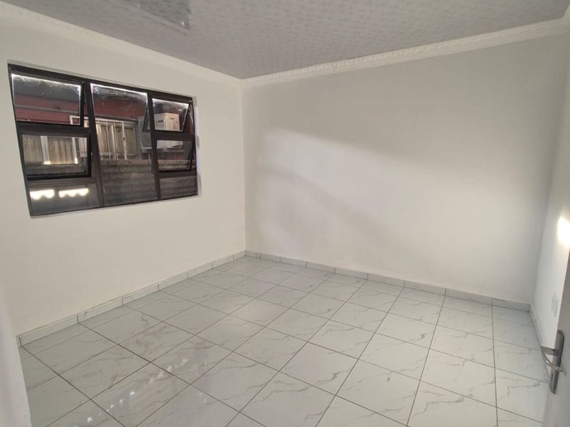 A clean, empty bedroom featuring modern white marble-look floor tiles and aluminium window frames, ready for personalization.