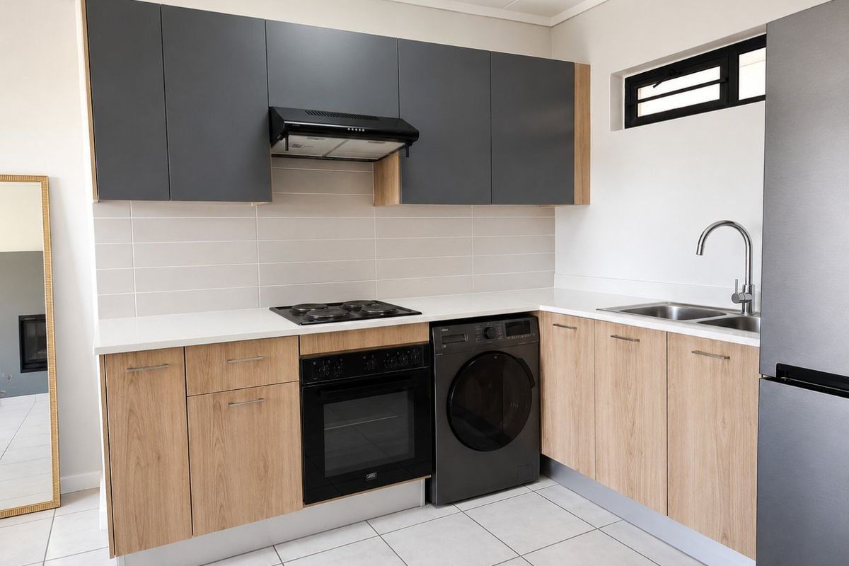 Modern kitchen featuring two-tone cabinetry, integrated oven and hob, tiled backsplash, and sleek countertops in a clean, well-maintained space.