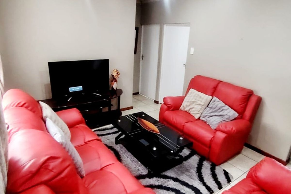 A living room featuring tiled flooring and coved ceiling details, providing a functional space for relaxation.