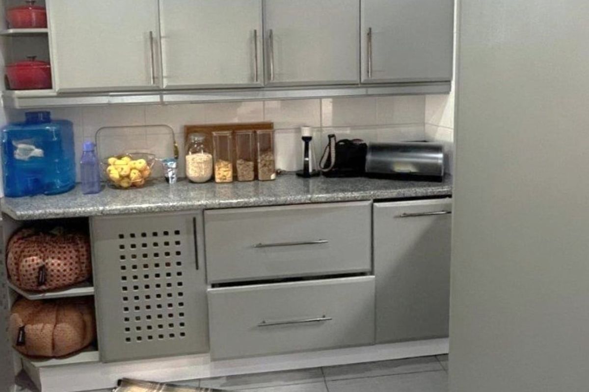 A compact kitchen area featuring modern grey cabinetry, granite countertops, and neutral tiled flooring, providing a functional and clean workspace.