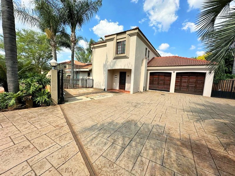 Front exterior view of a two-story residence featuring a double garage, stamped concrete driveway, and a tiled roof.