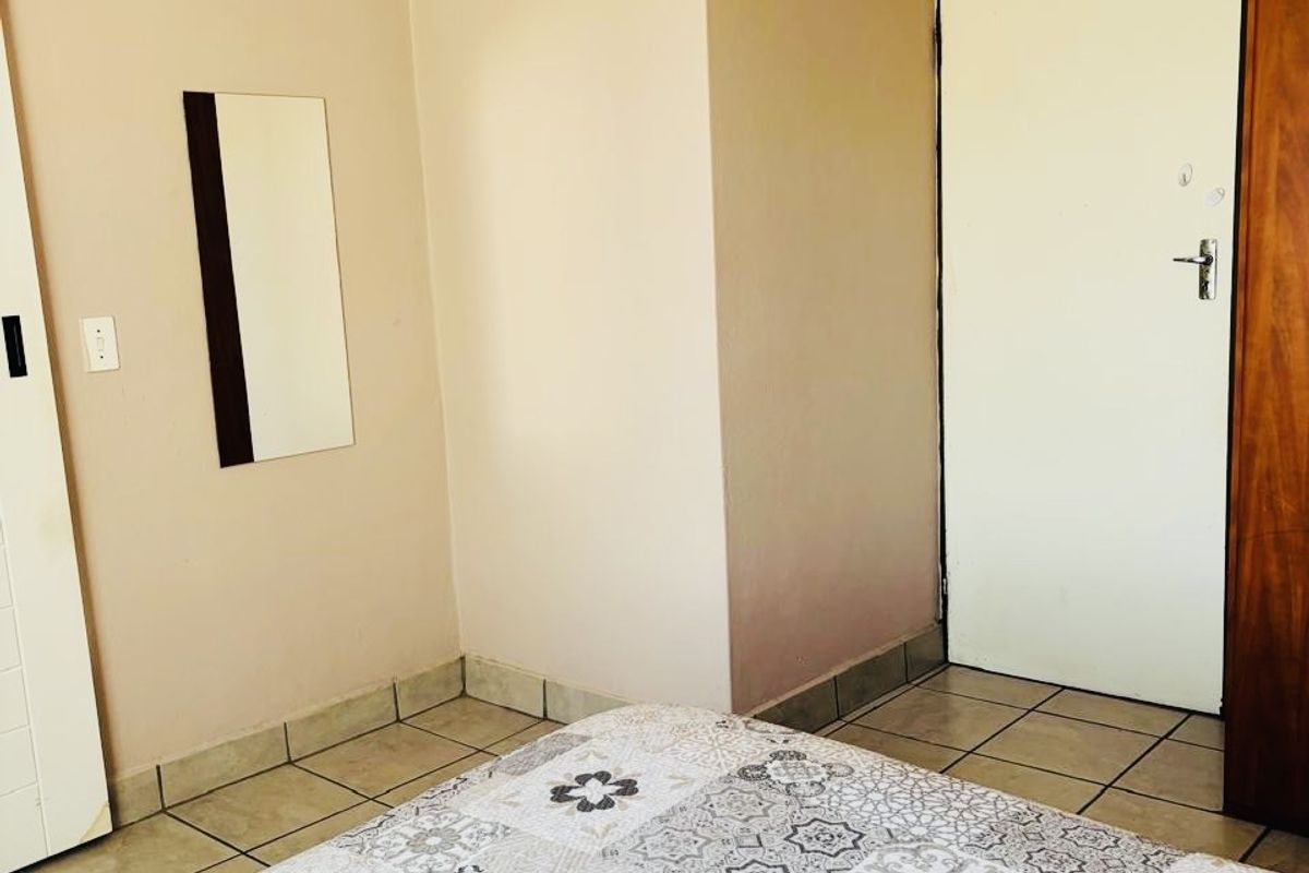A bedroom featuring tiled flooring and a built-in cupboard, providing functional storage space within the apartment.