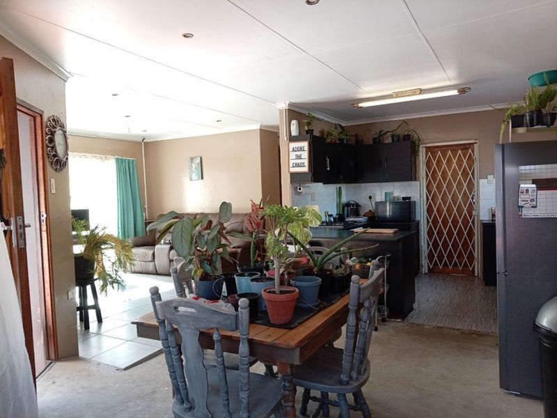 Open plan living and kitchen area featuring dark cabinetry, a central island, and tiled flooring, providing a functional layout for daily living.
