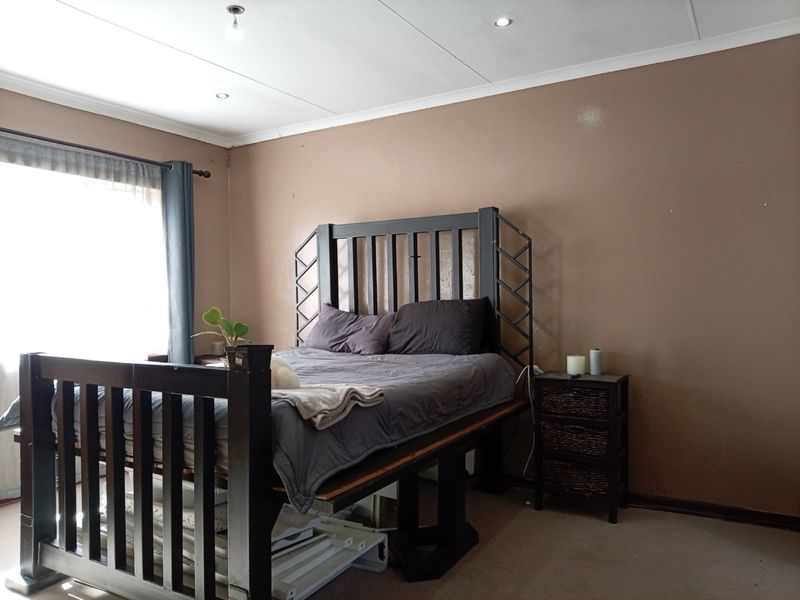 A standard bedroom featuring carpeted flooring, recessed downlighting, and coved ceiling details, providing a functional space ready for cosmetic updates.