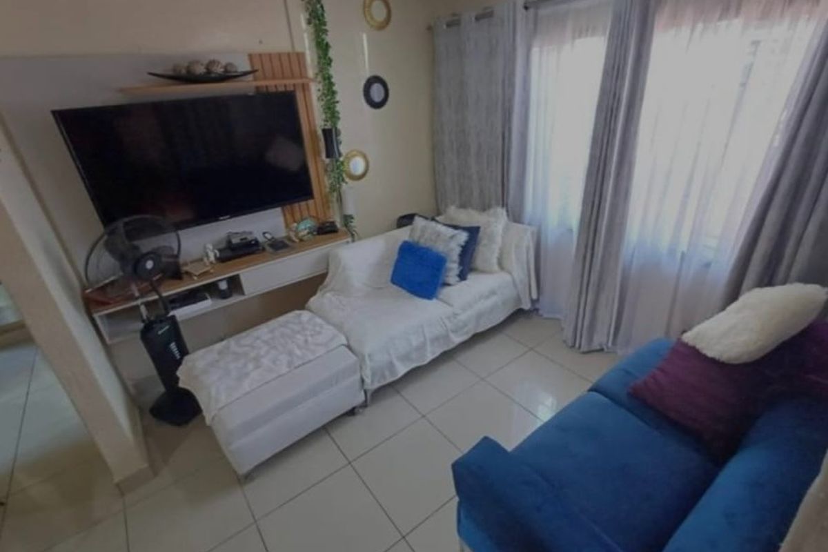 A compact living room featuring tiled flooring and a built-in media console, offering a functional space for relaxation.