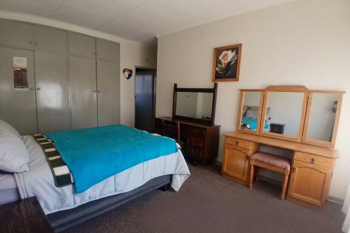 A functional bedroom featuring built-in cupboards and neutral wall finishes, offering a practical space ready for modern updates.