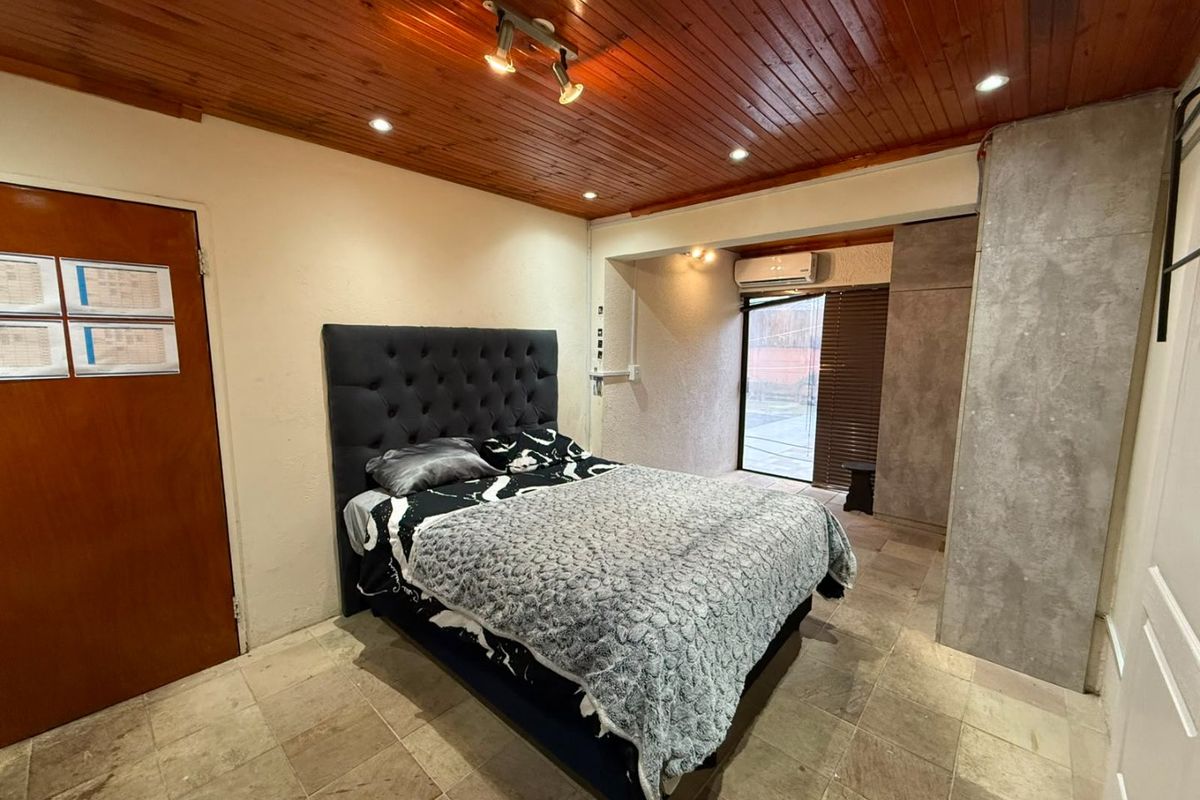Bedroom featuring a timber-clad ceiling, tiled flooring, built-in wardrobe, and split-system air conditioning with direct access to an outdoor area.
