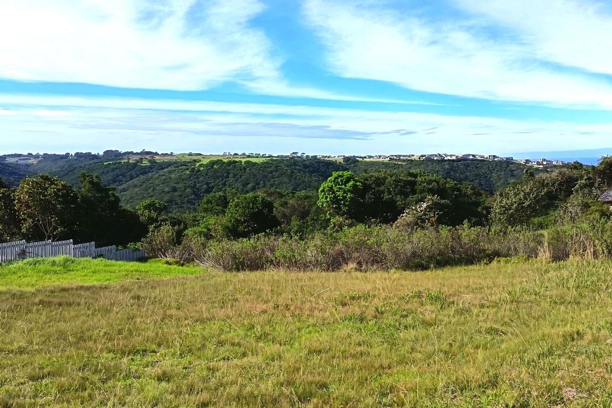 A scenic view overlooking a lush green valley and rolling hills, showcasing the natural landscape and open space of the residential land.
