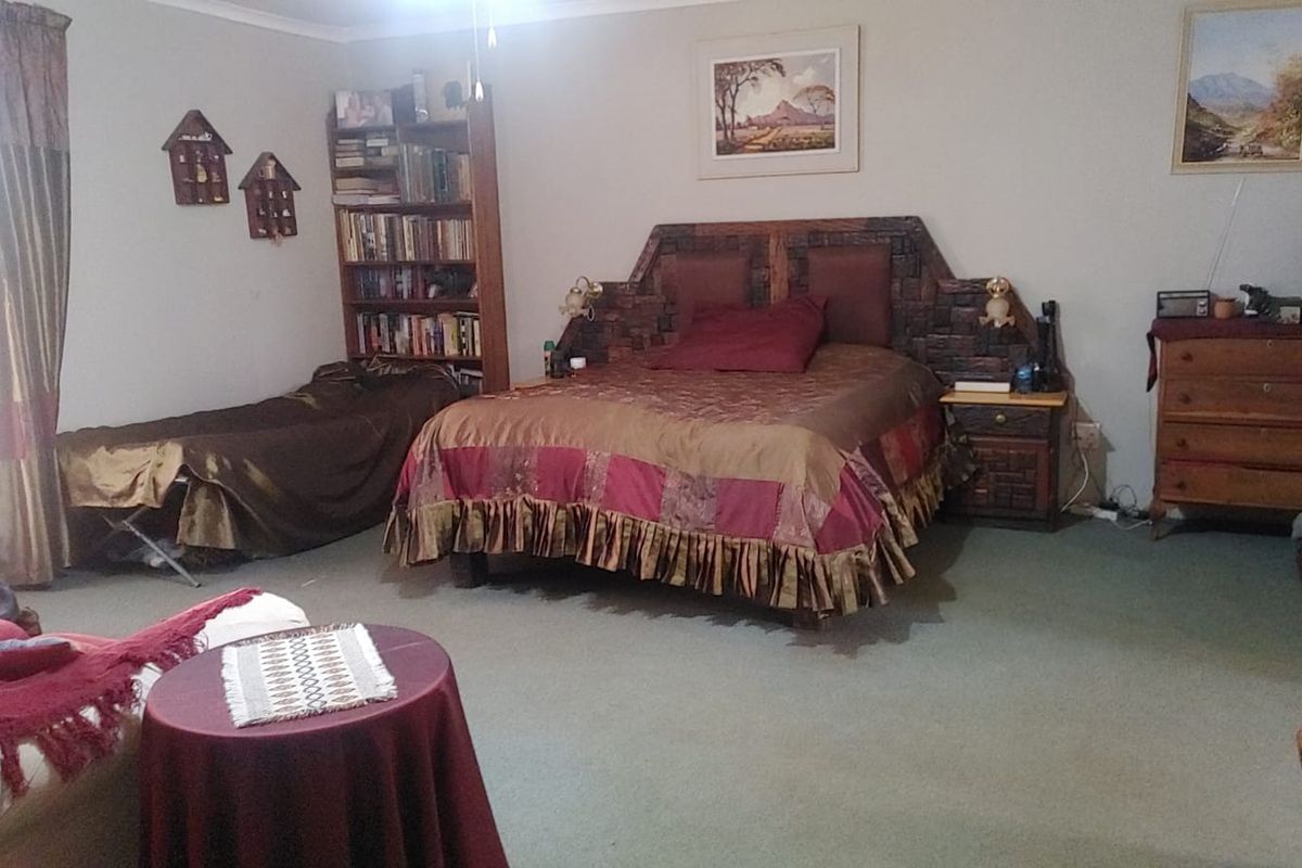 A spacious bedroom featuring carpeted flooring and coved ceilings, offering a comfortable layout with ample room for furniture.
