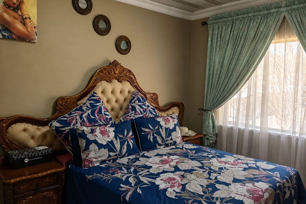 A cozy bedroom featuring crown molding and a window with curtains, providing a comfortable and private sleeping space.