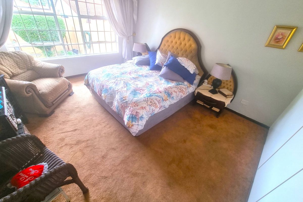 Spacious bedroom featuring large windows for natural light and built-in storage, currently finished with wall-to-wall carpeting.