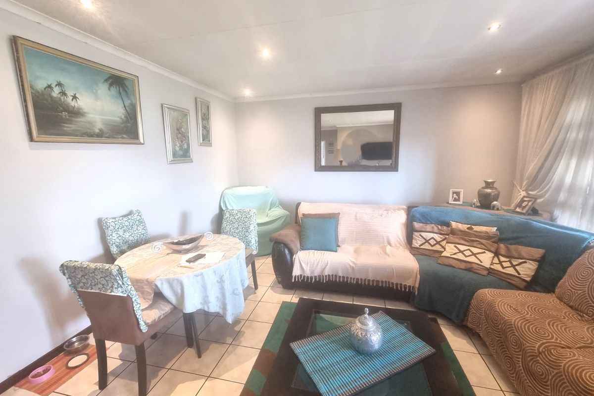 A comfortable living room featuring tiled flooring and recessed downlighting, providing a functional and neutral space for relaxation.