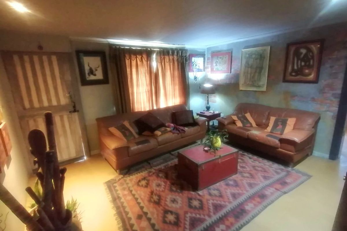A living room featuring an exposed brick wall and recessed lighting, providing a cozy and rustic atmosphere.
