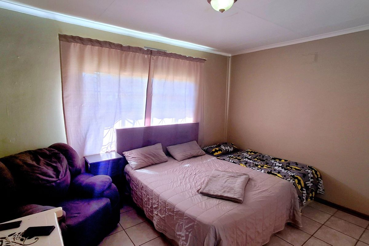 A standard bedroom featuring tiled flooring and a central ceiling light fixture, providing a functional living space.