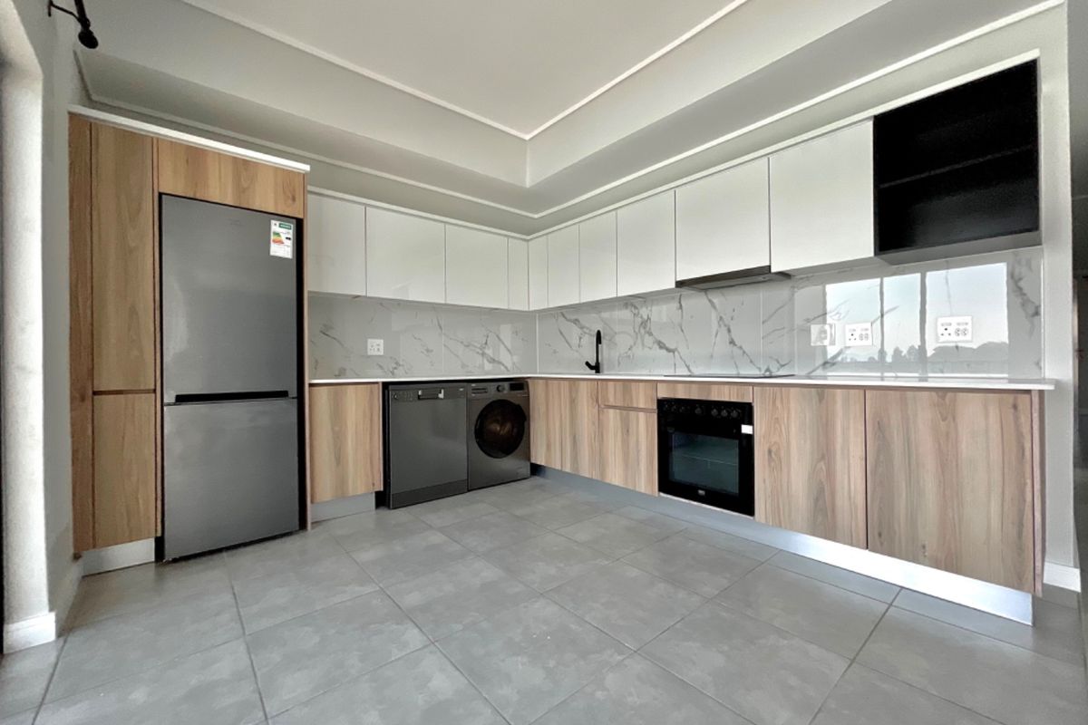 Modern kitchen featuring sleek wood-tone and white cabinetry, marble-look splashback, stone countertops, and integrated appliances in a clean, contemporary layout.