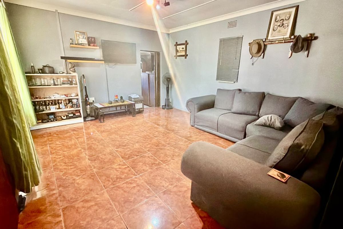 A spacious living room featuring tiled flooring and a ceiling fan, offering a functional layout for comfortable family living.