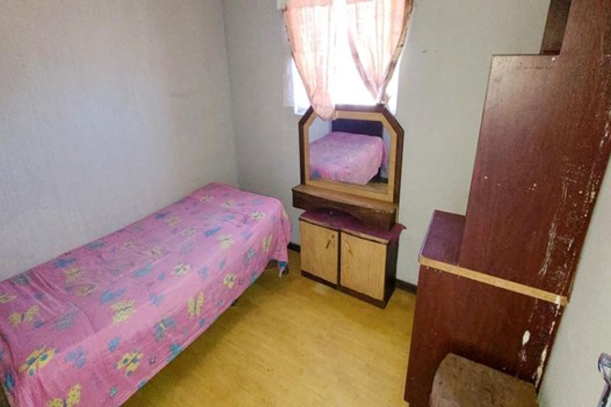 A compact bedroom featuring basic finishes, suitable for a single bed or as a small study area.