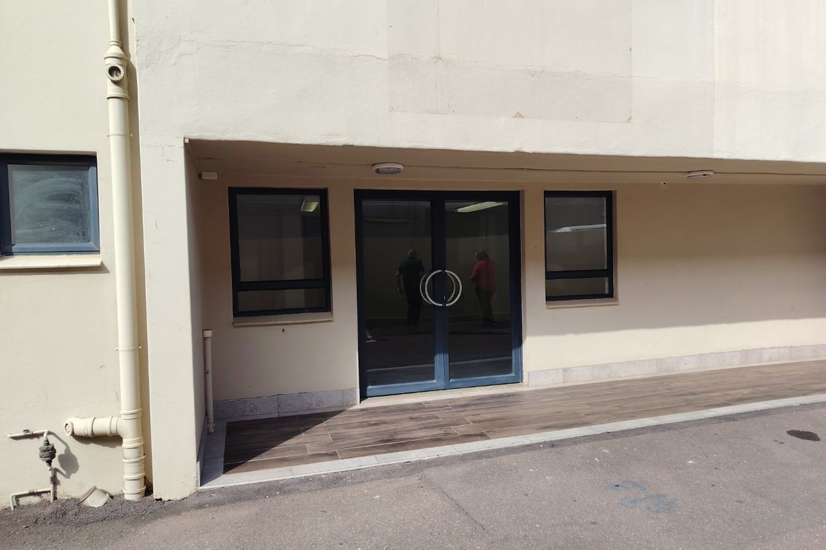 Front entrance of the industrial property featuring double glass doors, aluminium window frames, and a tiled porch area.