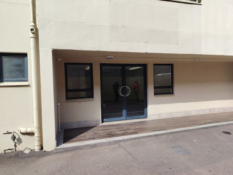 Front entrance of the industrial property featuring double glass doors, aluminium window frames, and a tiled porch area.