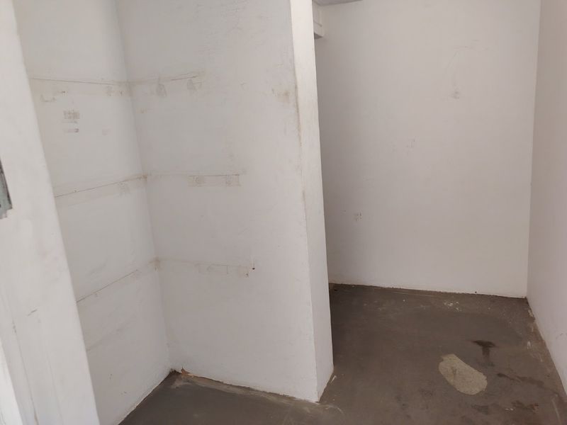 An empty utility or storage space featuring concrete flooring and partition walls, suitable for various industrial or storage applications.